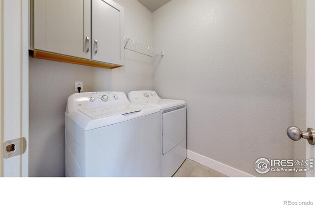 4157 Trapper Lake Dr, Loveland, CO 80538 - clothes washing area featuring washing machine and clothes dryer, cabinet space, baseboards, and light tile patterned floors