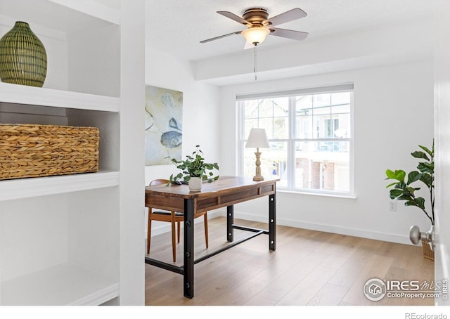 office space with plenty of natural light, wood finished floors, a ceiling fan, and baseboards