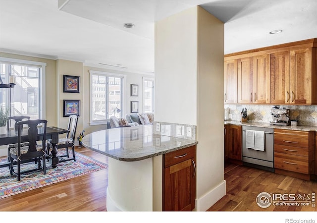 kitchen with dishwasher, dark wood-style floors, plenty of natural light, backsplash, and ornamental molding