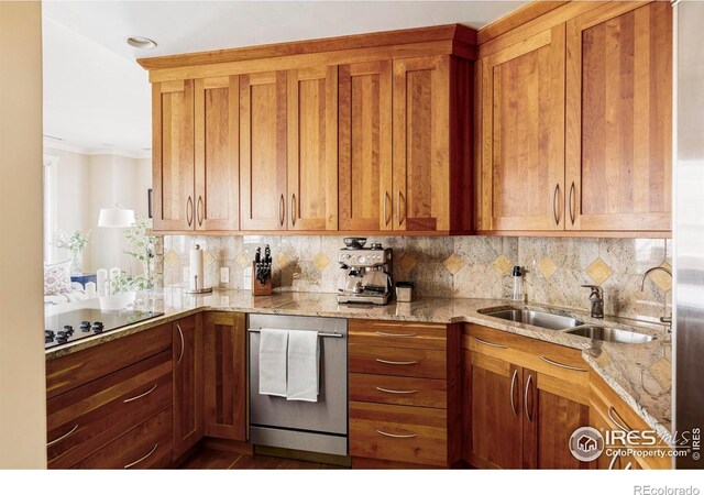 kitchen featuring black electric cooktop, a sink, brown cabinets, and decorative backsplash