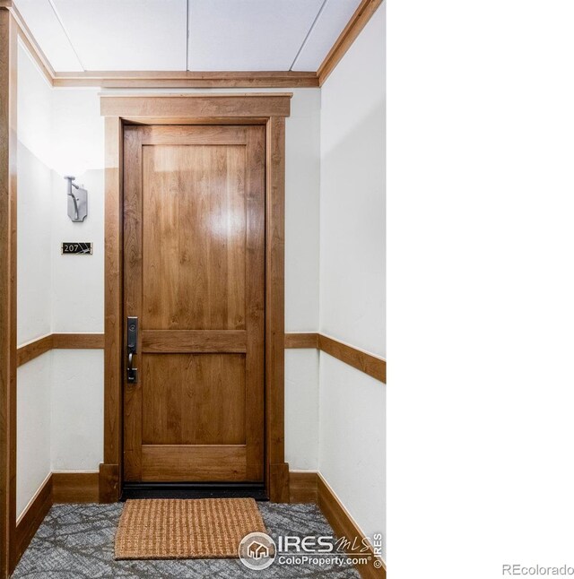 entryway with ornamental molding and baseboards