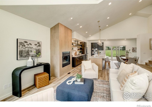 5304 Vardon Way, Fort Collins, CO 80528 - living area featuring light wood finished floors, a large fireplace, high vaulted ceiling, and recessed lighting