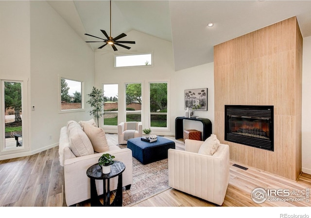 5304 Vardon Way, Fort Collins, CO 80528 - living room with a glass covered fireplace, ceiling fan, high vaulted ceiling, and light wood-style flooring