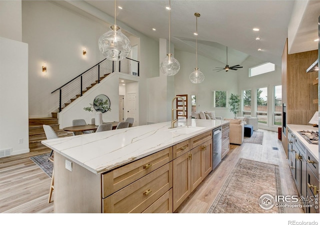 5304 Vardon Way, Fort Collins, CO 80528 - kitchen featuring open floor plan, high vaulted ceiling, a ceiling fan, light wood-style flooring, and a kitchen bar