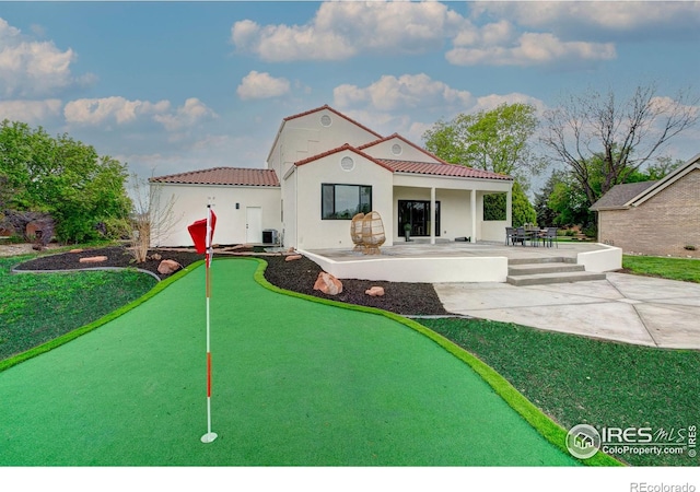 5304 Vardon Way, Fort Collins, CO 80528 - rear view of house with a patio area, a tiled roof, an area to practice putting, and stucco siding