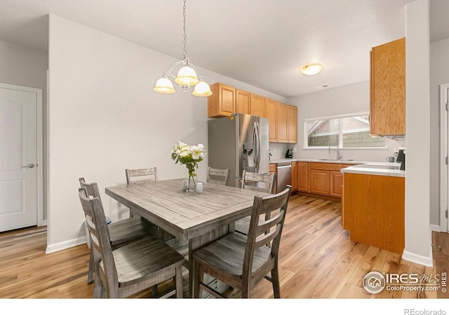 dining room featuring light wood-style floors, a chandelier, and baseboards