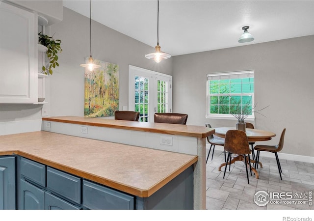 1369 Padfield Pl, Erie, CO 80516 - kitchen featuring a peninsula, blue cabinetry, light countertops, pendant lighting, and baseboards