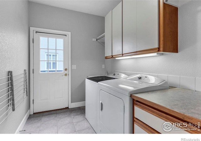 1369 Padfield Pl, Erie, CO 80516 - clothes washing area featuring cabinet space, washing machine and dryer, light tile patterned flooring, and baseboards