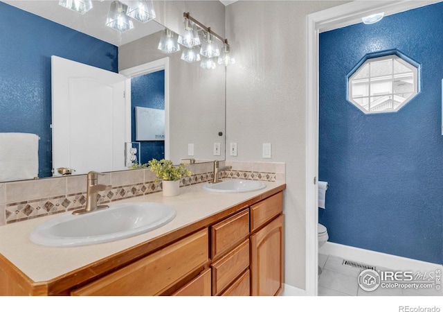 1369 Padfield Pl, Erie, CO 80516 - bathroom with tile patterned flooring, toilet, double vanity, a textured wall, and baseboards