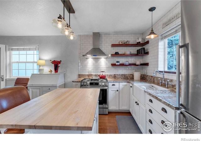 1369 Padfield Pl, Erie, CO 80516 - kitchen featuring stainless steel appliances, butcher block countertops, wall chimney exhaust hood, a sink, and white cabinetry