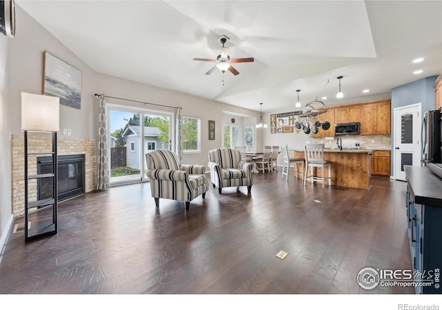 1458 S Dusk Dr, Milliken, CO 80543 - living room featuring ceiling fan, dark wood finished floors, lofted ceiling, a glass covered fireplace, and recessed lighting