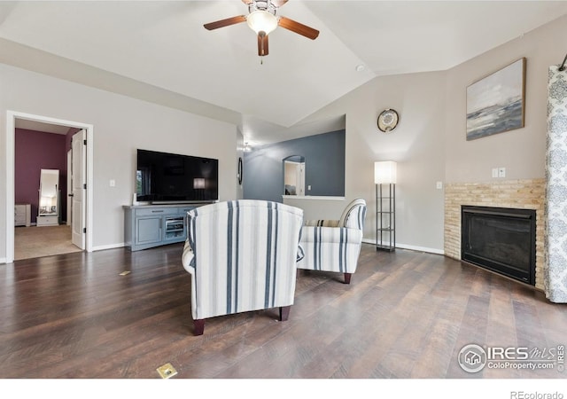 1458 S Dusk Dr, Milliken, CO 80543 - living area with a ceiling fan, lofted ceiling, dark wood-style floors, a glass covered fireplace, and baseboards