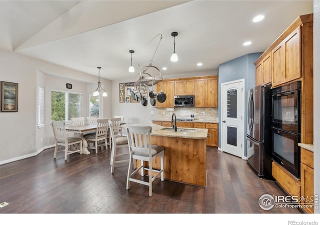1458 S Dusk Dr, Milliken, CO 80543 - kitchen with stainless steel appliances, tasteful backsplash, decorative light fixtures, recessed lighting, and a center island with sink