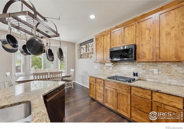 1458 S Dusk Dr, Milliken, CO 80543 - kitchen featuring appliances with stainless steel finishes, decorative backsplash, recessed lighting, light stone countertops, and dark wood-style flooring