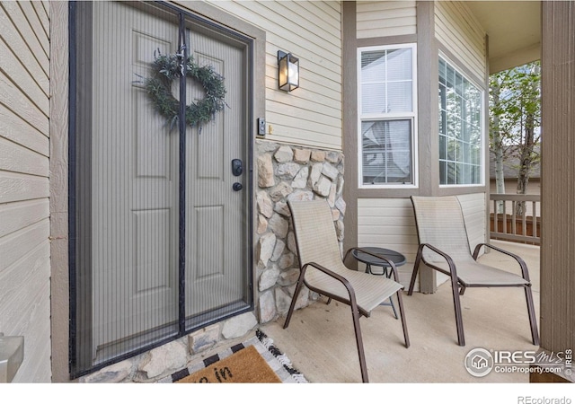 property entrance featuring covered porch and stone siding
