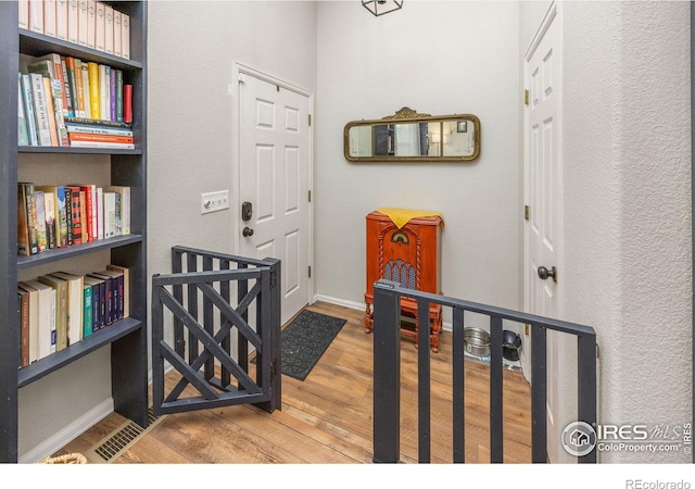 corridor featuring wood finished floors and baseboards