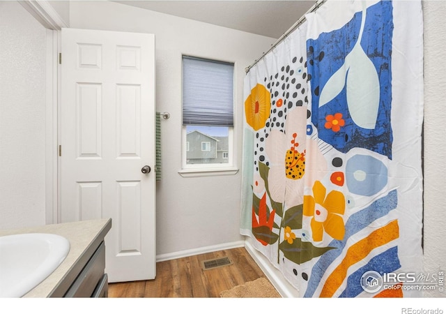 bathroom featuring wood finished floors, vanity, baseboards, and a shower with shower curtain