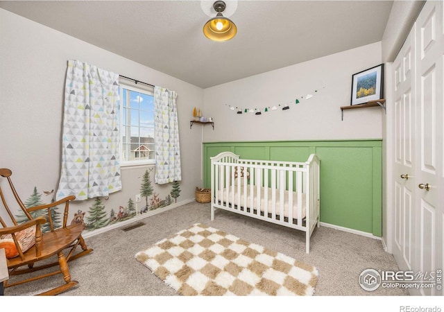 carpeted bedroom with a closet and baseboards