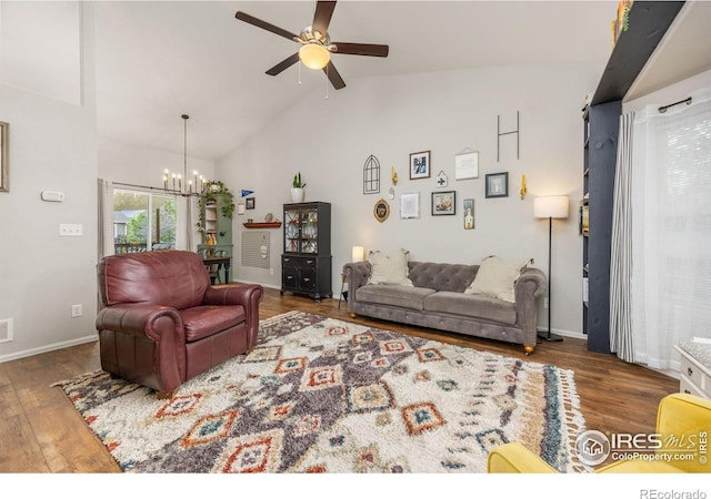living room with a chandelier, ceiling fan, wood finished floors, high vaulted ceiling, and baseboards