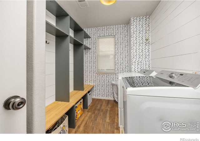 laundry area featuring separate washer and dryer, dark wood-style flooring, and wallpapered walls