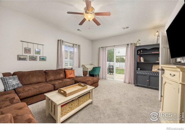 carpeted living room with ceiling fan