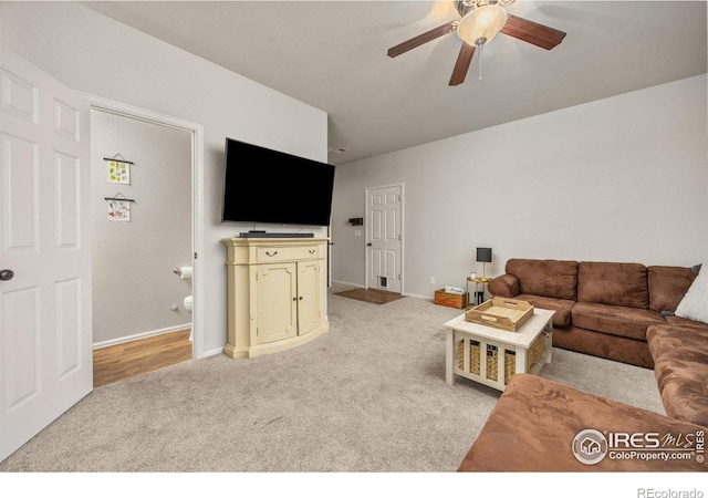living room with light carpet, ceiling fan, and baseboards