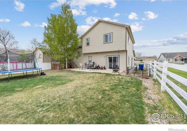 rear view of property featuring a trampoline and a patio