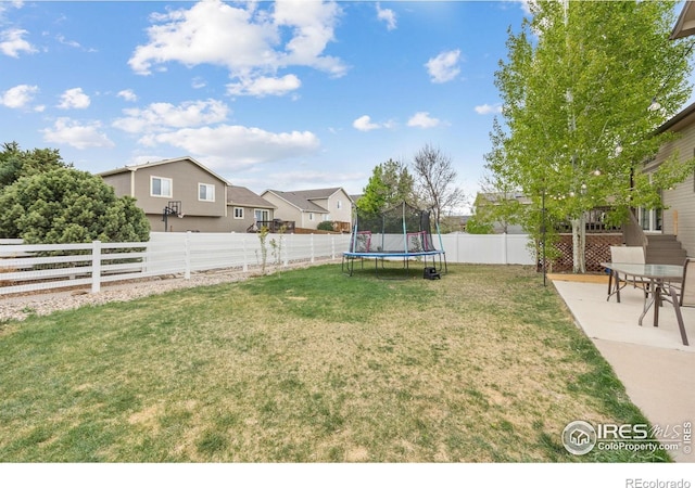 view of yard featuring a trampoline, a residential view, and a patio area