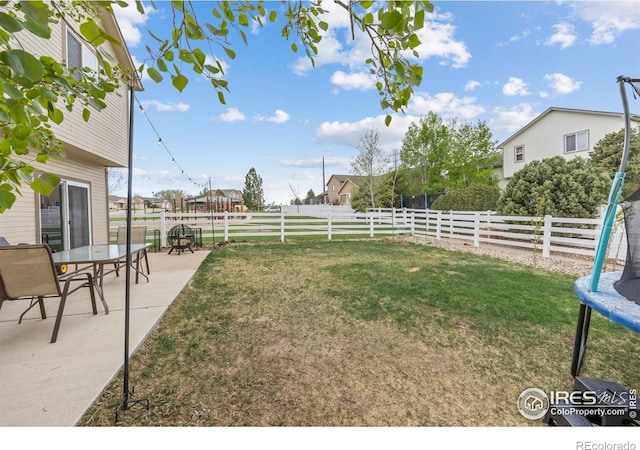 view of yard featuring a trampoline and a patio area