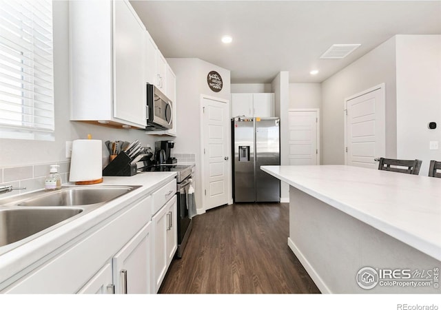 602 Santa Fe Trl Unit D1, Ault, CO 80610 - kitchen featuring appliances with stainless steel finishes, dark wood finished floors, white cabinets, light countertops, and a sink