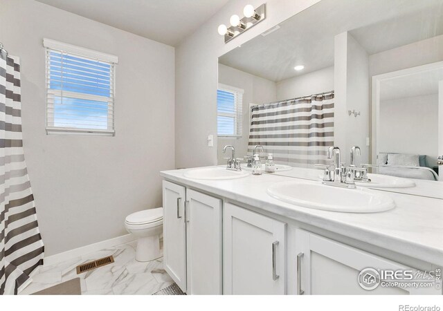 602 Santa Fe Trl Unit D1, Ault, CO 80610 - full bath featuring marble look tile flooring, toilet, double vanity, baseboards, and a shower with shower curtain