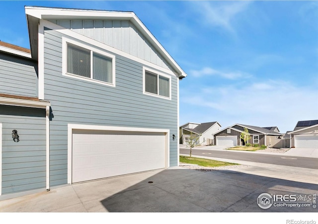 602 Santa Fe Trl Unit D1, Ault, CO 80610 - view of home's exterior with board and batten siding, an attached garage, and a residential view