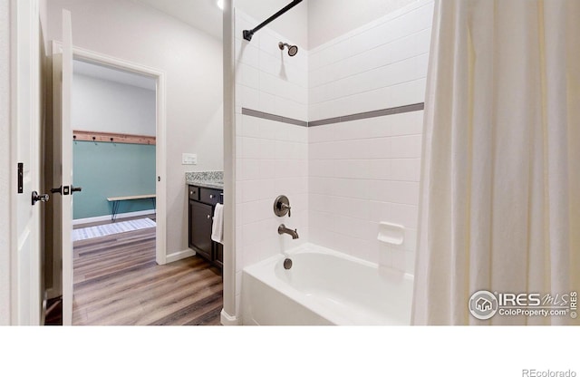 bathroom featuring shower / bath combo with shower curtain, wood finished floors, and vanity