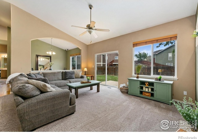 living room featuring arched walkways, lofted ceiling, ceiling fan, and carpet