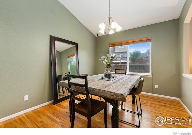 dining space featuring a chandelier, healthy amount of natural light, light wood-style floors, baseboards, and lofted ceiling