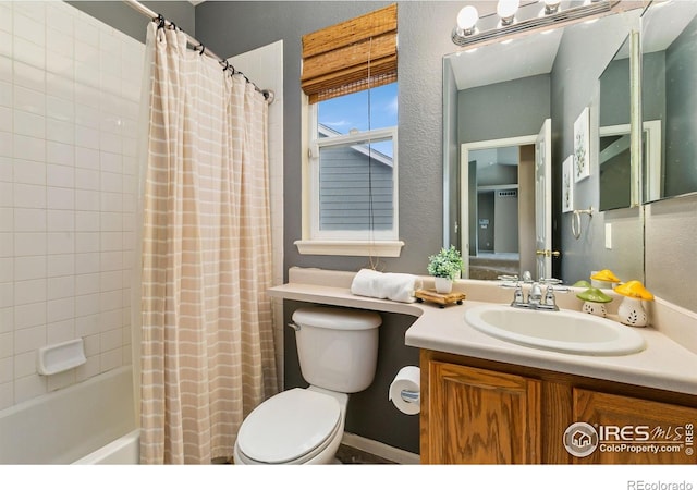 full bathroom featuring toilet, vanity, shower / tub combo, and a textured wall