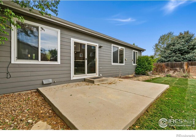 rear view of property with a patio and fence