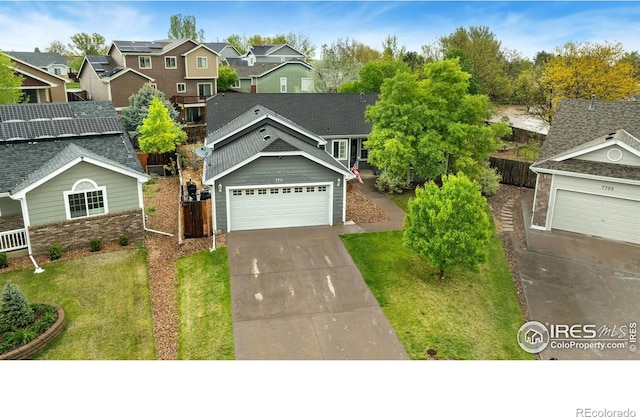 traditional-style home featuring driveway, a residential view, and an attached garage