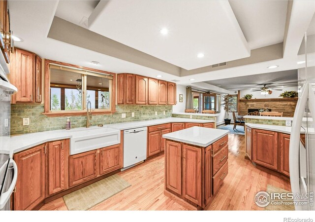 14531 Country Hills Dr, Brighton, CO 80601 - kitchen with dishwasher, a sink, decorative backsplash, ceiling fan, and light wood-style flooring