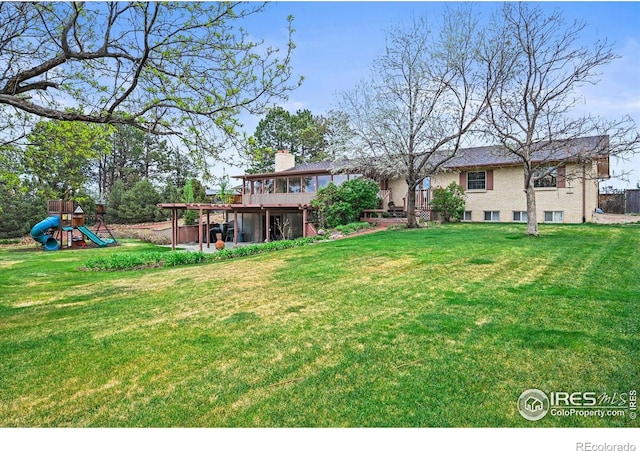 14531 Country Hills Dr, Brighton, CO 80601 - view of green lawn with a playground and a wooden deck