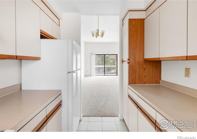 3260 47th St Unit 207A, Boulder, CO 80301 - kitchen featuring light colored carpet, white cabinetry, a chandelier, freestanding refrigerator, and light tile patterned floors