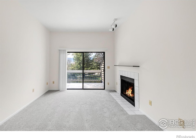 3260 47th St Unit 207A, Boulder, CO 80301 - unfurnished living room with carpet floors, a fireplace, track lighting, and baseboards