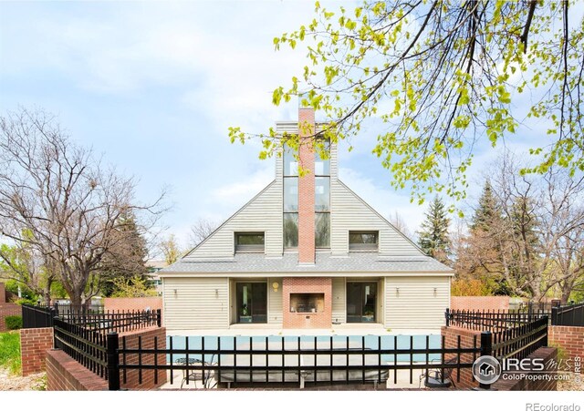 3260 47th St Unit 207A, Boulder, CO 80301 - back of house with a fenced front yard, a pool, a chimney, a patio area, and a shingled roof