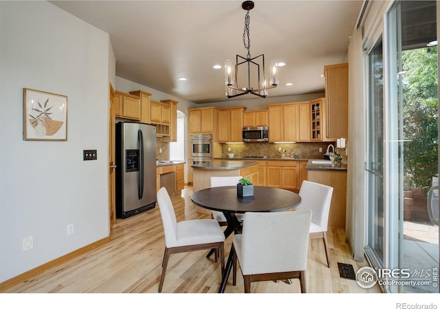 dining room featuring light wood finished floors, a chandelier, recessed lighting, and baseboards