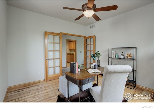 office with light wood-style floors and a ceiling fan