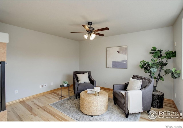 sitting room featuring ceiling fan, wood finished floors, and baseboards