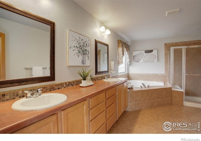 full bathroom with a garden tub, a shower stall, tile patterned floors, decorative backsplash, and double vanity