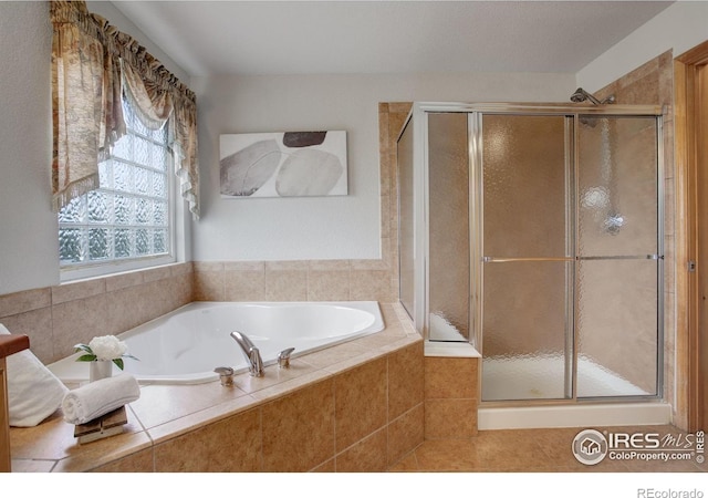 bathroom featuring a stall shower, a garden tub, and tile patterned flooring