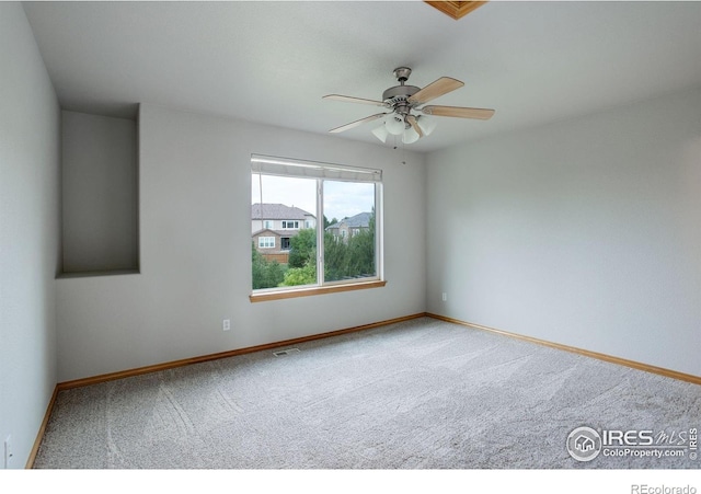 unfurnished room featuring carpet floors, a ceiling fan, and baseboards