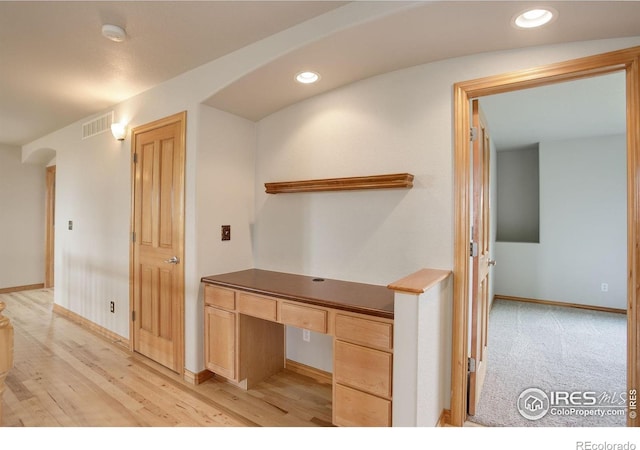 unfurnished office with arched walkways, baseboards, built in study area, recessed lighting, and light wood-style floors